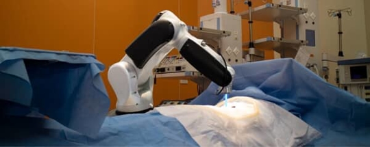 Robot arm performing surgery on covered patient